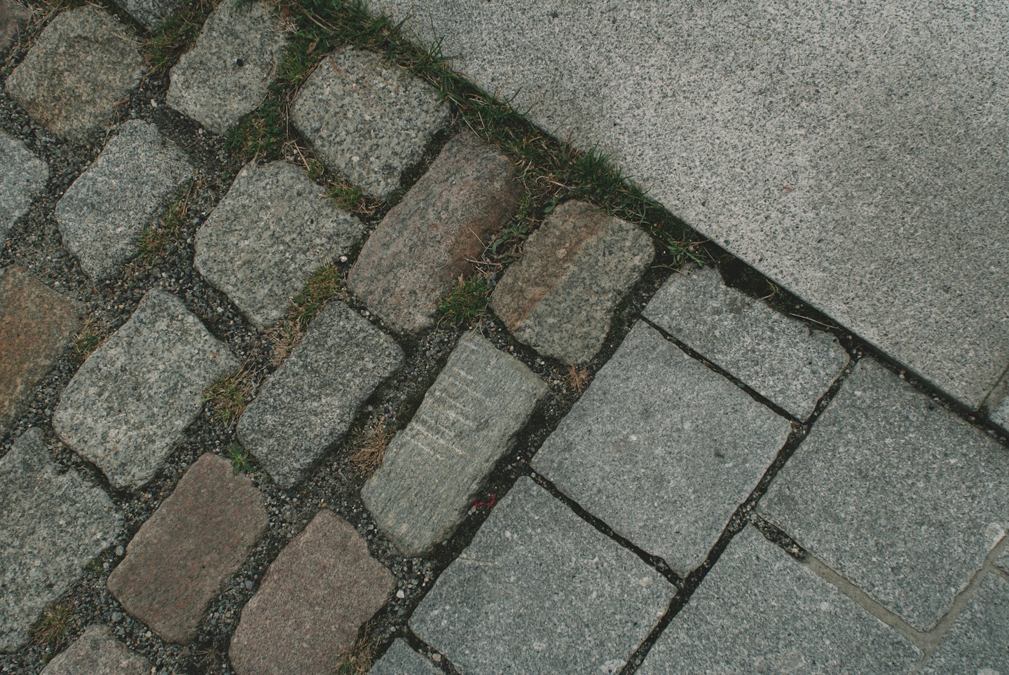 Brukowce i kamienne płyty spotykające się na zewnętrznej ścieżce.